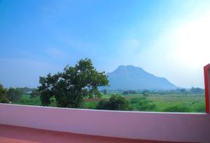 a view of a mountain from a white ledge at JR Residency in Usilampatti