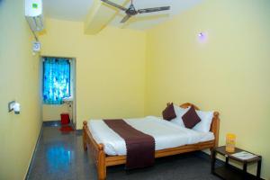 a bedroom with a bed and a ceiling fan at JR Residency in Usilampatti