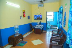 a room with blue and yellow walls and a table and chairs at JR Residency in Usilampatti