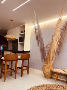 a living room with a table and two chairs and a vase at Mahalo Exclusive Boutique in Maragogi