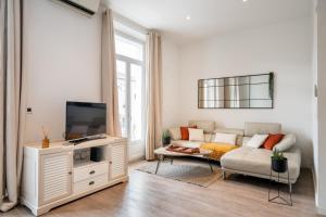 een woonkamer met een bank en een tv bij Hyper centre Cannes - 2 pièces avec balcon - 4 couchages in Cannes