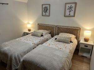 twee bedden naast elkaar in een slaapkamer bij Ker Zélia in Cruguel