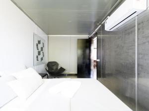 een slaapkamer met een wit bed en een raam bij Casa Container Moderna com Vista da Natureza em Itajaí in Itajaí +26 foto's