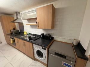 a kitchen with a sink and a washing machine at 2 Bedroom Ground Floor Flat with Kitchen & Parking in Uxbridge