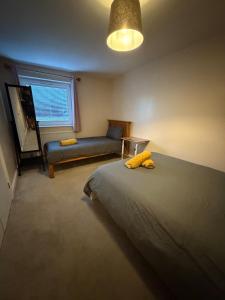 a bedroom with a bed and a couch at 2 Bedroom Ground Floor Flat with Kitchen & Parking in Uxbridge