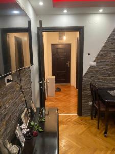 a living room with a table and a brick wall at Apartman u Srcu Vranja in Vranje