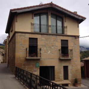 uma antiga casa de pedra com janelas e uma varanda em Casa Rural Baigorrietxea em Villabuena de Álava