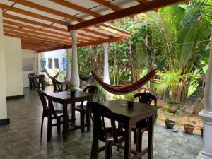 a patio with tables and chairs and a hammock at Bakery Family Guest House in Mirissa +118 photos