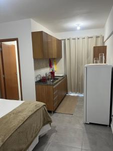 een slaapkamer met een bed en een keuken met een aanrecht bij Studio Sereno in Barbacena