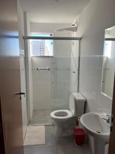 een badkamer met een douche, een toilet en een wastafel bij Studio Sereno in Barbacena