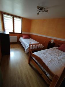 two beds in a room with two windows at Les Balcons de Valezan in La Plagne Tarentaise