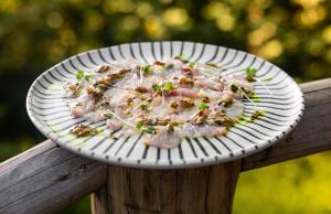 a plate of food on top of a wooden rail at Villa Das Contas Boutique in Itacaré