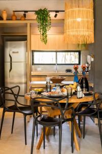 une cuisine avec une table en bois et des chaises noires dans l'établissement Casa Vilas Patacho Garden, à Porto de Pedras