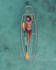 une femme dans un bateau sur l'eau dans l'établissement Casa Vilas Patacho Garden, à Porto de Pedras