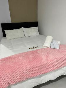 a bed with a pink and white blanket on it at Malibu Dream in Gqeberha