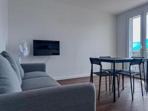 ein Wohnzimmer mit Sofa, Tisch und Stühlen in der Unterkunft Le Second Verderet in Grenoble