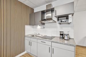 a kitchen with white cabinets and a sink at HanseStay Wandsbek in Hamburg +23 photos