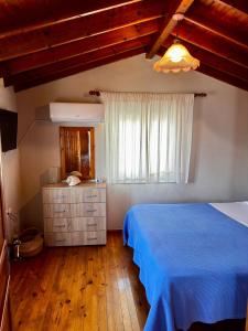 ein Schlafzimmer mit einem blauen Bett und einem Fenster in der Unterkunft Ireon Seaside Breeze studio in Ireo