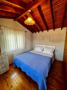 ein Schlafzimmer mit einem großen Bett und einer blauen Decke in der Unterkunft Ireon Seaside Breeze studio in Ireo