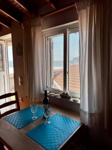 einen Tisch mit zwei Weingläsern und einem Fenster in der Unterkunft Ireon Seaside Breeze studio in Ireo