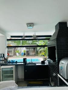 een keuken met een wastafel en een stenen open haard bij Pousada Montblanc suíte 4 in Guarujá