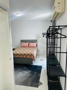 een slaapkamer met een bed en een wenteltrap bij Pousada Montblanc suíte 4 in Guarujá