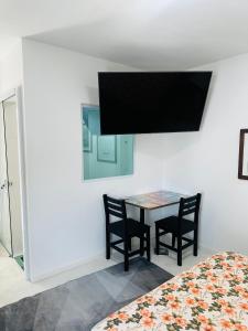 een kamer met een tafel en twee stoelen en een televisie bij Pousada Montblanc suíte 4 in Guarujá +17 foto's