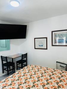 a bedroom with a bed and a table with chairs at Pousada Montblanc suíte 4 in Guarujá +17 photos