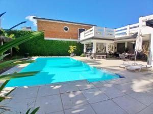 a swimming pool in front of a house at Pousada Montblanc suíte 4 in Guarujá