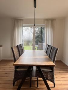einem Esstisch mit 2 Stühlen und einem Fenster in der Unterkunft Ruhig & großzügig für 8 Pers, WLAN & Feuerschale in Rahden