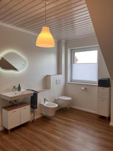 ein Badezimmer mit Waschbecken und Toilette und einem Fenster in der Unterkunft Ruhig & großzügig für 8 Pers, WLAN & Feuerschale in Rahden