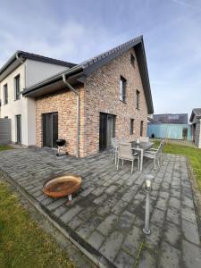 eine Terrasse mit Tisch und Stühlen und ein Gebäude in der Unterkunft Ruhig & großzügig für 8 Pers, WLAN & Feuerschale in Rahden