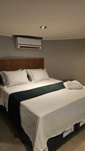 une chambre avec un grand lit avec des draps blancs dans l'établissement Chalés Feliz Boipeba, à Cairu