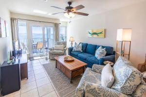 un soggiorno con un divano blu e un tavolo di Whispering Sands #202 a Coffeyville