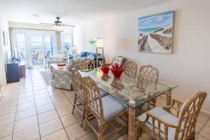 una sala da pranzo e un soggiorno con tavolo e sedie in vetro di Whispering Sands #202 a Coffeyville