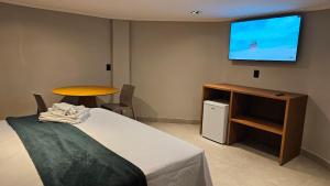 une chambre avec un lit et une télévision à écran plat dans l'établissement Chalés Feliz Boipeba, à Cairu 8 autres photos