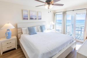 una camera bianca con un letto e una grande finestra di Whispering Sands #202 a Coffeyville