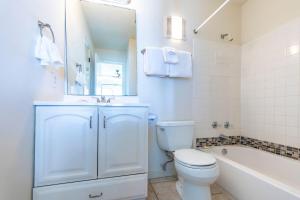 e bagno bianco con servizi igienici, lavandino e vasca. di Whispering Sands #202 a Coffeyville Altre 39 foto