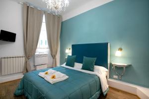 a blue bedroom with a bed with towels on it at Residenza Centro Storico in Lucca +28 photos