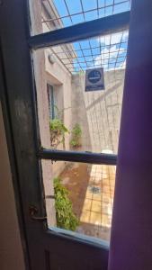 an open door with a view of a courtyard through a window at Dpto 6 in La Cieneguita