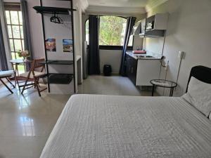 a bedroom with a bed and a kitchen and a table at Singular Coyoacán Pepper My Love! in Mexico City