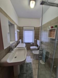 un bagno con due wc, un lavandino e una doccia di Orion House ad Ardenno Altre 29 foto
