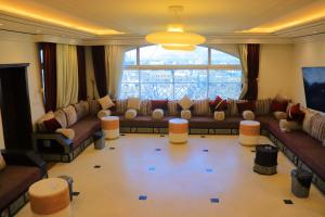 un soggiorno con divani e una grande finestra di تحت التجهيز a ‘Aţţān