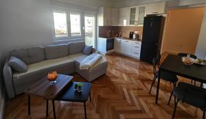 a living room with a couch and a kitchen at Modern Apartment - Capljina Center in Čapljina