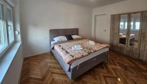 a bedroom with a large bed and a mirror at Modern Apartment - Capljina Center in Čapljina