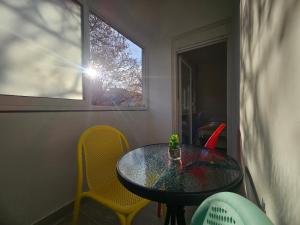 a table and chairs in a room with a window at Modern Apartment - Capljina Center in Čapljina +3 photos