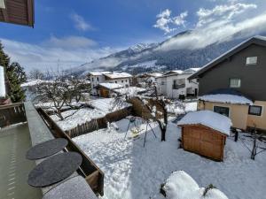 un cortile coperto da neve con case e una montagna di Nussbaumer a Lengdorf