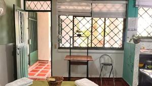 a table and a chair in a room with a window at La Magia del Atardecer - Studio 02 in Santa Marta