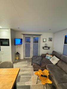 a living room with a couch and a table at Strandnest Renesse in Renesse