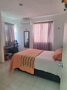 a bedroom with a large bed and a chair in it at Comfortable and nice house in Caucel in Mérida